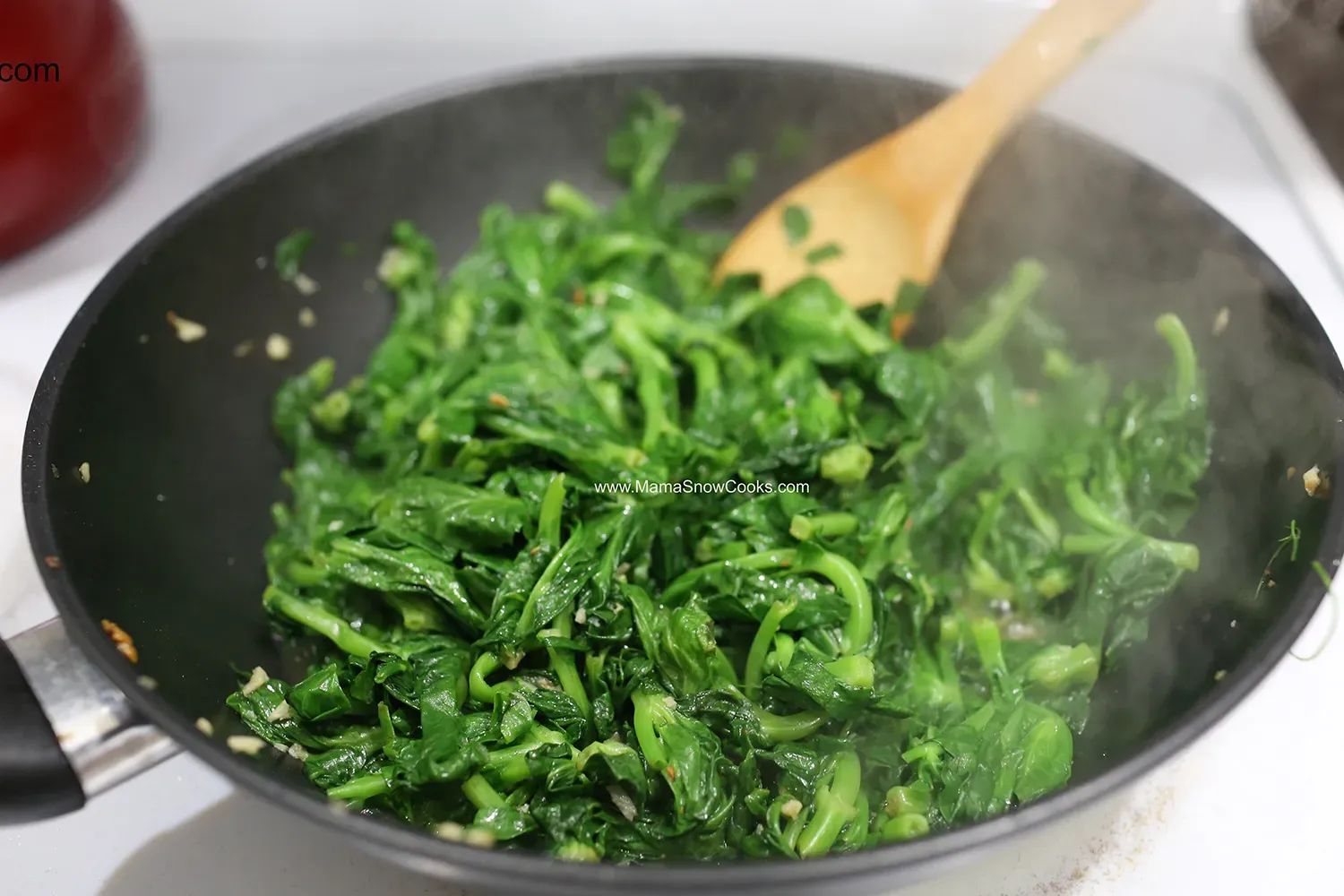 Rau được thêm gia vị và đảo đều trong chảo