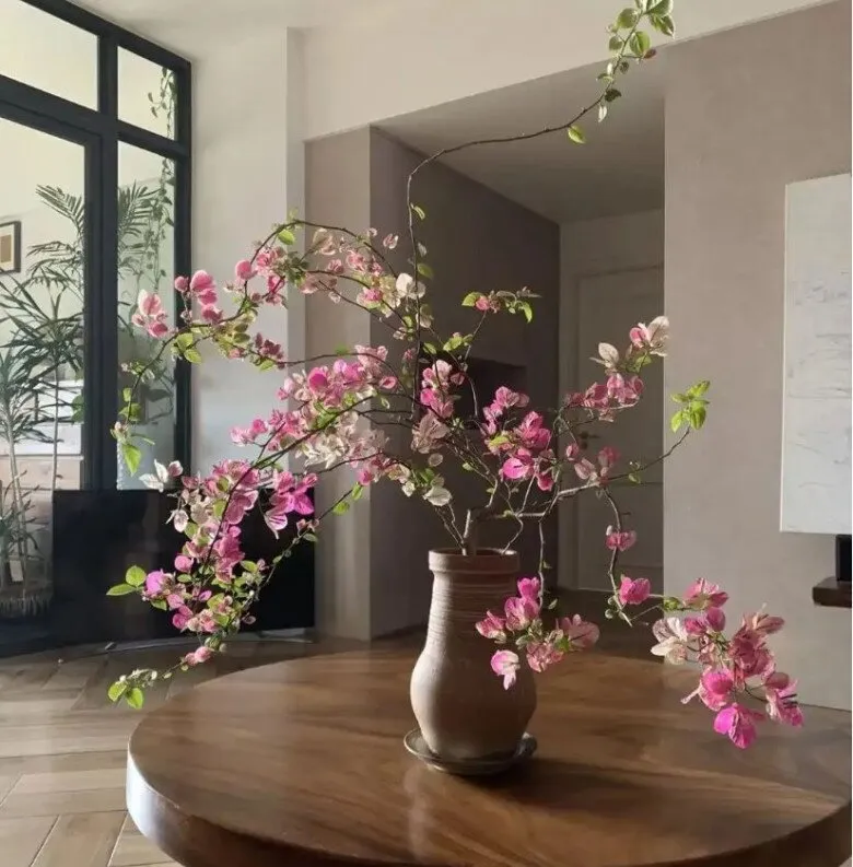 Một chậu hoa giấy nhỏ được đặt trên bàn, tạo điểm nhấn tinh tế cho không gian phòng khách.